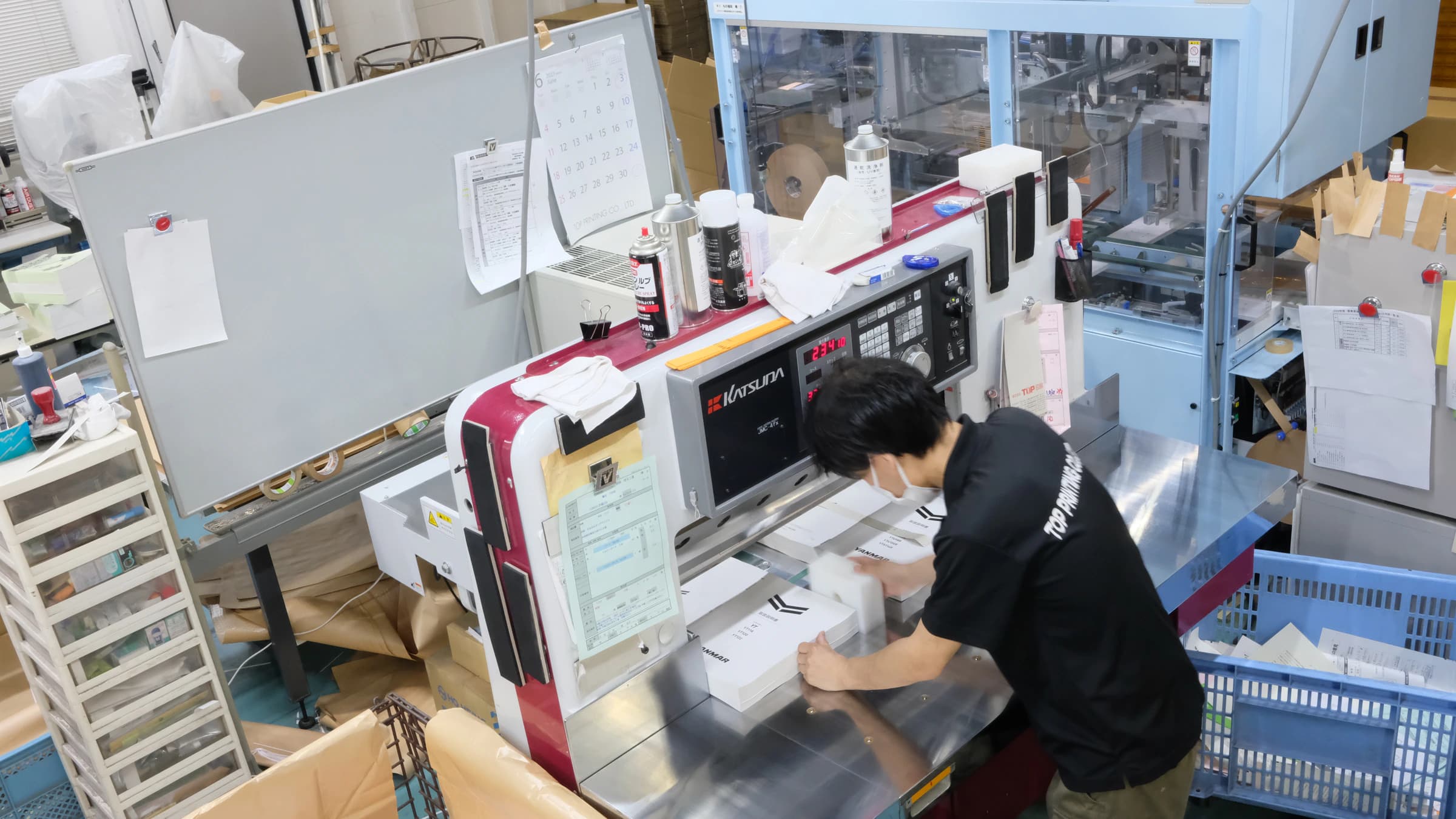 自社工場で冊子を製本するスタッフ